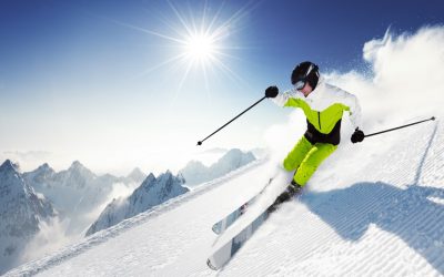 Skier in mountains, prepared piste and sunny day